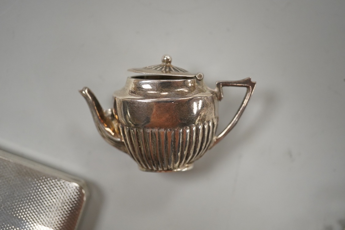 A George V silver presentation key, Vaughton & Sons, Birmingham, 1910, 10.2cm, together with a silver cigarette case, a silver and mother of pearl fruit knife, a miniature 925 demi-fluted teapot and a Scottish hardstone